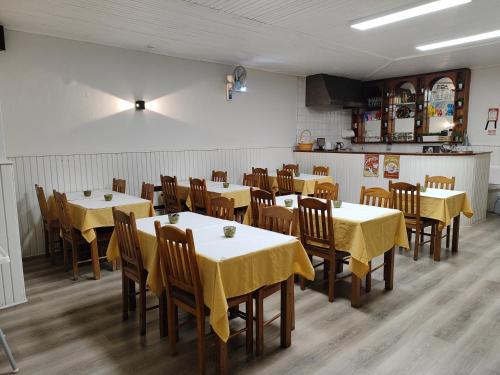 uma sala de jantar com mesas e cadeiras com toalha de mesa amarela em Residencial Centro Comercial Avenida Bragashopping em Braga