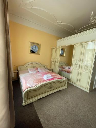 a bedroom with a large bed with pink sheets at Apartmány vila Týniště in Týniště nad Orlicí