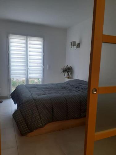 - une chambre avec un lit doté d'une couette noire et d'une fenêtre dans l'établissement Maison familiale cosy., à Saint-Bauzille-de-Montmel