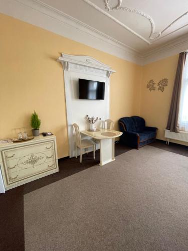 a living room with a table and a couch at Apartmány vila Týniště in Týniště nad Orlicí