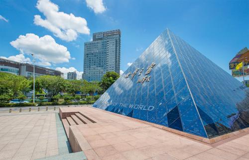 ein Glasgebäude in einer Stadt mit hohen Gebäuden in der Unterkunft The Westin Shenzhen Nanshan in Shenzhen