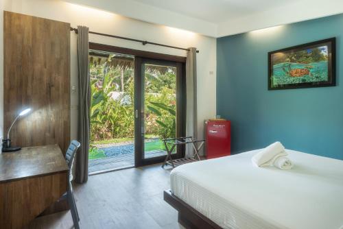 Palaka Resort في جنرال لونا: غرفة نوم بسرير ومكتب ونافذة