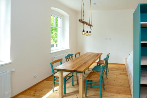 a dining room with a wooden table and chairs at NaturparkResort GeoApartment in Gams bei Hieflau