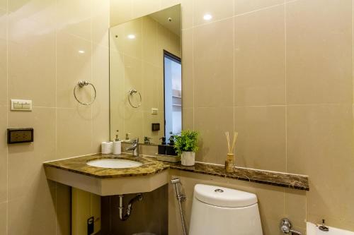 a bathroom with a toilet and a sink and a mirror at TC Contel At Sukhumvit Nana in Bangna