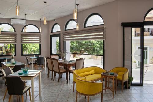 a restaurant with tables and chairs and windows at Kalimera Andros in Andros