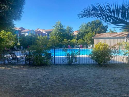 une clôture en face d'une piscine dans l'établissement residence les rives marines bassin d arcachon, au Teich