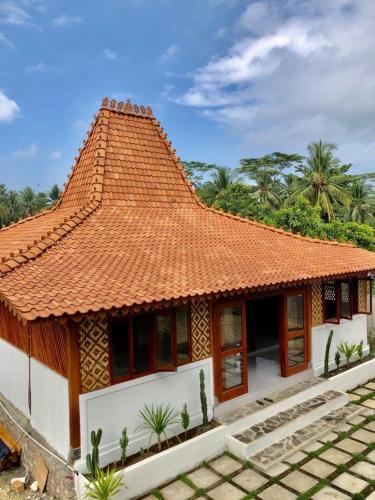 a house with an orange tile roof on top at Hideaway Batukaras in Pangandaran
