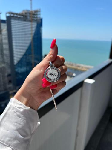 a person holding a stopwatch in their hand at Moonlight Apart-Hotel Batumi in Batumi