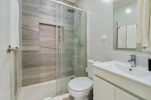 a bathroom with a shower and a toilet and a sink at Harmony Setúbal in Setúbal