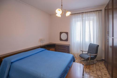 una camera con un letto blu e una sedia di Da Tina a Portoferraio