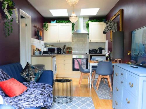 ein Wohnzimmer mit einem blauen Sofa und einer Küche in der Unterkunft 1 Bedroom Apartment -Sleeps 3- Big Savings On Long Stays! in Kent