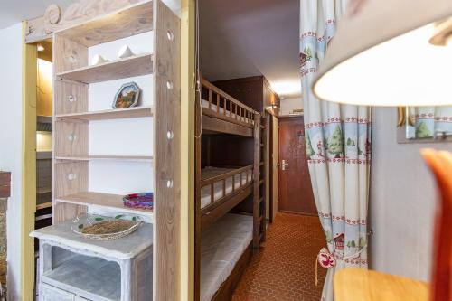 a small room with a bunk bed with shelves at Appartement Pieds des Pistes in Saint-Lary-Soulan