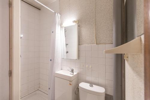 Baño blanco con aseo y lavamanos en Appartement Pieds des Pistes en Saint-Lary-Soulan