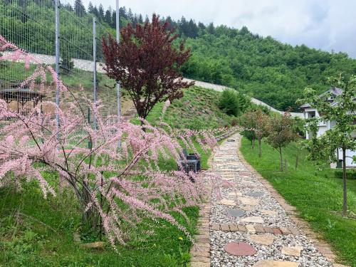 a garden with pink flowers and a stone path at Countryside Resort Sarajevo in Hadžići
