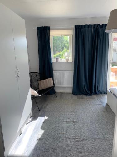 a room with blue curtains and a chair and a window at Großzuegiges Haus im Wald in Immeln