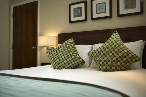 a bedroom with a bed with two pillows on it at The Bull in Gerrards Cross