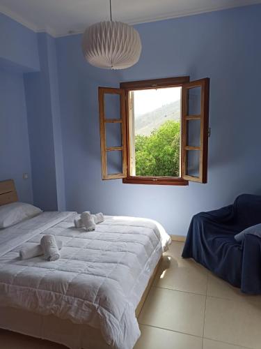 a bedroom with two beds and a window at Studio in Upper Symi in Symi