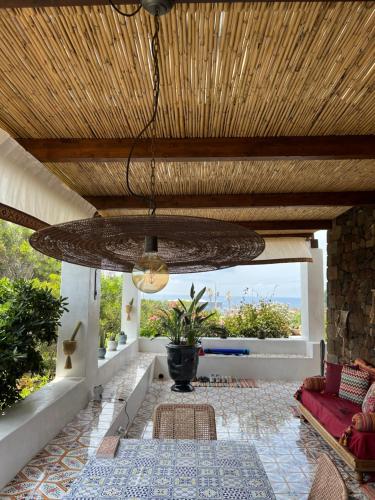 een woonkamer met een houten plafond en een grote kroonluchter bij Dammuso Pensare alla Luna in Pantelleria