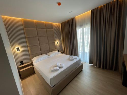 a bedroom with a large white bed and a window at Absolute Hotel Ksamil in Ksamil