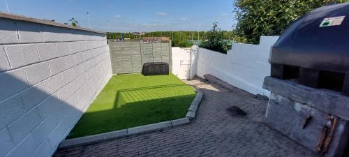 a small yard of grass on the side of a building at Modern City Centre House in Heart of Galway City in Galway