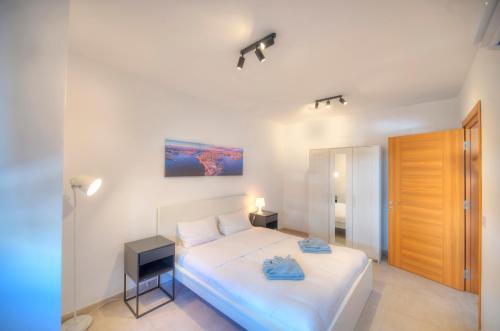 - une chambre avec un lit blanc et une porte en bois dans l'établissement Spacious & Tastefully furnished 3 bedrooms RCUT1-1, à Is-Swieqi