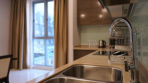a kitchen with a sink and a window at Marina Puteri Harbour Johor by Perfect Host in Nusajaya
