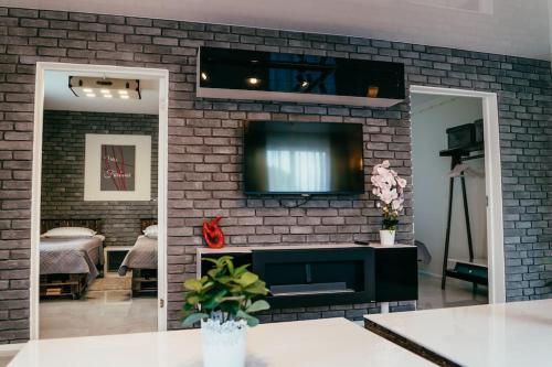 a living room with a tv on a brick wall at Villa Fortuna in Ludza