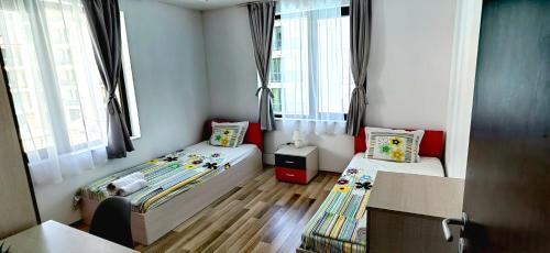 um pequeno quarto com duas camas e janelas em Family Apartments Amadeus lux em Sunny Beach