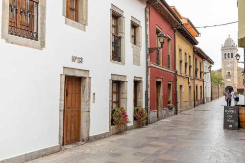 an empty street with buildings and a person walking down the street at Apartamento Playa de Luanco Lux in Luanco