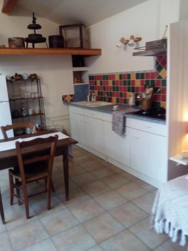 une cuisine avec une table et une table ainsi qu'une salle à manger dans l'établissement Sous les pins, à Villeneuve-lès-Avignon
