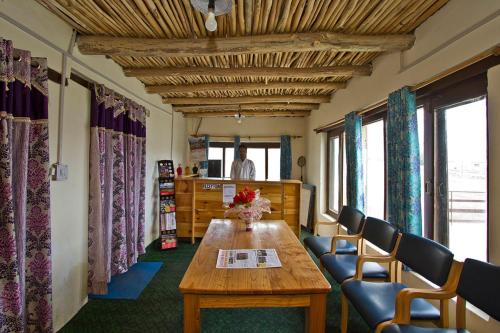a room with a wooden table and chairs and windows at Pangong Retreat Camp in Spangmik