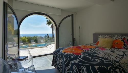 une chambre avec un lit et une vue sur une piscine dans l'établissement Séjour de Luxe à Golfe Juan, 15 mn de Cannes, à Vallauris