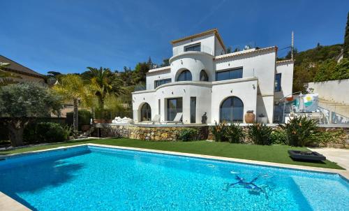 une villa avec piscine devant une maison dans l'établissement Séjour de Luxe à Golfe Juan, 15 mn de Cannes, à Vallauris