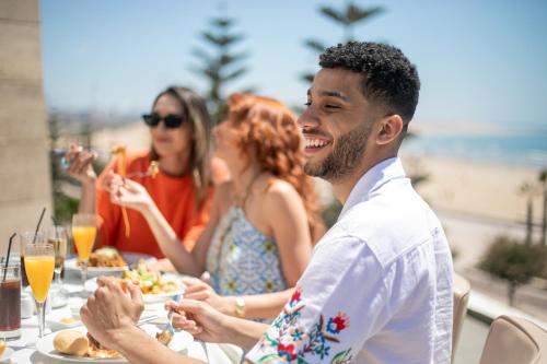 a group of people sitting at a table eating food at Atlas Essaouira Riad Resort in Essaouira