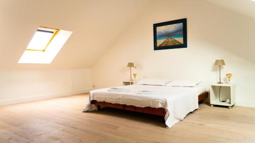 une chambre avec un grand lit dans un grenier dans l'établissement MAISON DE CARACTERE CENTRE VILLE PROCHE PLAGE, à Les Sables-dʼOlonne