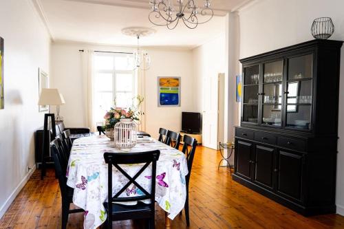 une salle à manger avec une table, des chaises et un lustre dans l'établissement MAISON DE CARACTERE CENTRE VILLE PROCHE PLAGE, à Les Sables-dʼOlonne