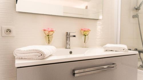 La salle de bains est pourvue d'un lavabo et de fleurs. dans l'établissement MAISON DE CARACTERE CENTRE VILLE PROCHE PLAGE, à Les Sables-dʼOlonne