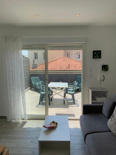un salon avec un canapé et une terrasse avec une table dans l'établissement Sunny studio - Magnan, Tramway-Proche aéroport, à Nice