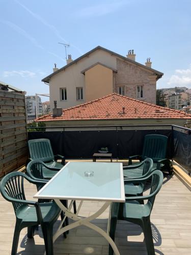 une table et des chaises blanches sur un toit dans l'établissement Sunny studio - Magnan, Tramway-Proche aéroport, à Nice