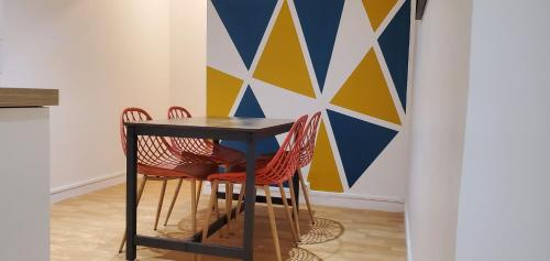 une table à manger avec des chaises et un mur géométrique dans l'établissement Charming Room with shared space close to PARIS - Chambres Confort avec espaces partagés proche de PARIS, à Vitry-sur-Seine