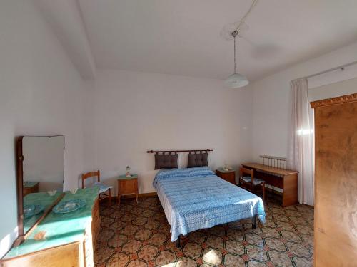 een slaapkamer met een bed, een bureau en een spiegel bij JONIA Appartamento vacanze vicino al mare con giardino in Pulsano