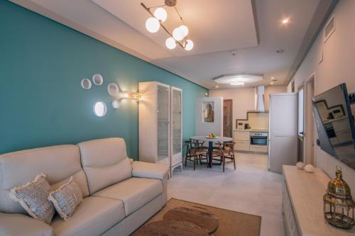 a living room with a white couch and a kitchen at Apartamentos Turísticos La Baílla in Rota