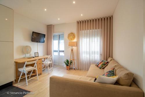 a living room with a couch and a dining room at Nesha Ericeira Flats in Ericeira