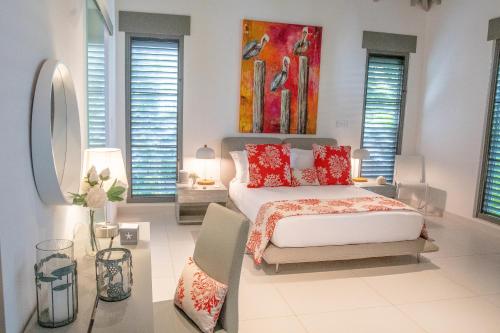 a bedroom with a bed and a painting on the wall at VIP The Beach House in Jolly Harbour