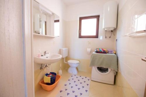 uma casa de banho com um lavatório e um WC em Apartmani Nedjeljko em Čunski