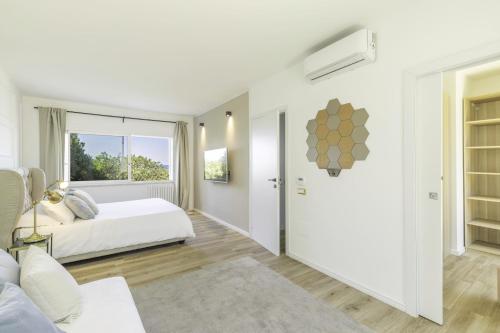 a white bedroom with a bed and a window at Villa Blanca del mar in Quartu SantʼElena
