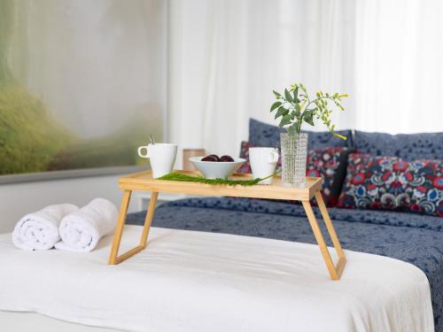 - une table en bois avec un plateau au-dessus du lit dans l'établissement Live Arico Burgado, à Arico