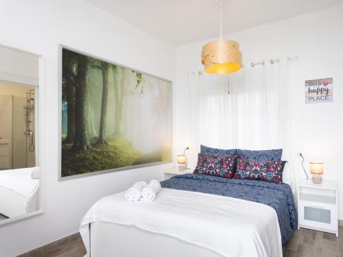 a bedroom with a bed and a painting on the wall at Live Arico Burgado in Arico