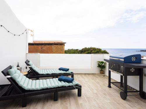 a balcony with two couches and a grill at Live Arico Burgado in Arico