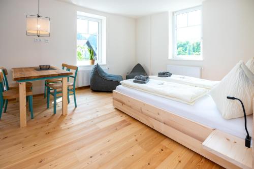a bedroom with a bed with a table and a dining room at NaturparkResort GeoApartment in Gams bei Hieflau